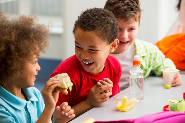 Children sharing fruit and conversation around a table