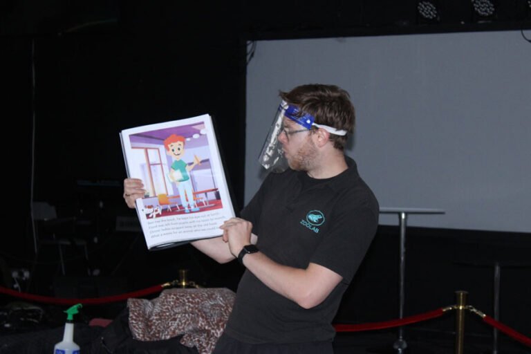 An activity leader using an illustrated card during an animal workshop