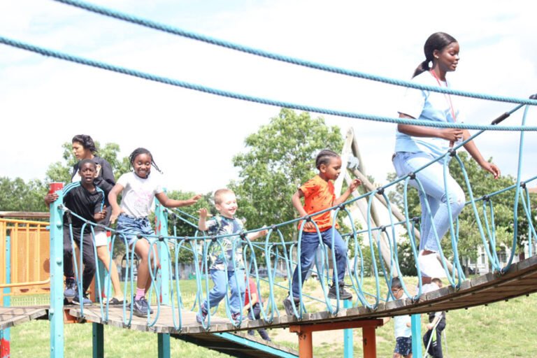 Children and adults crossing an outdoor rope bridge