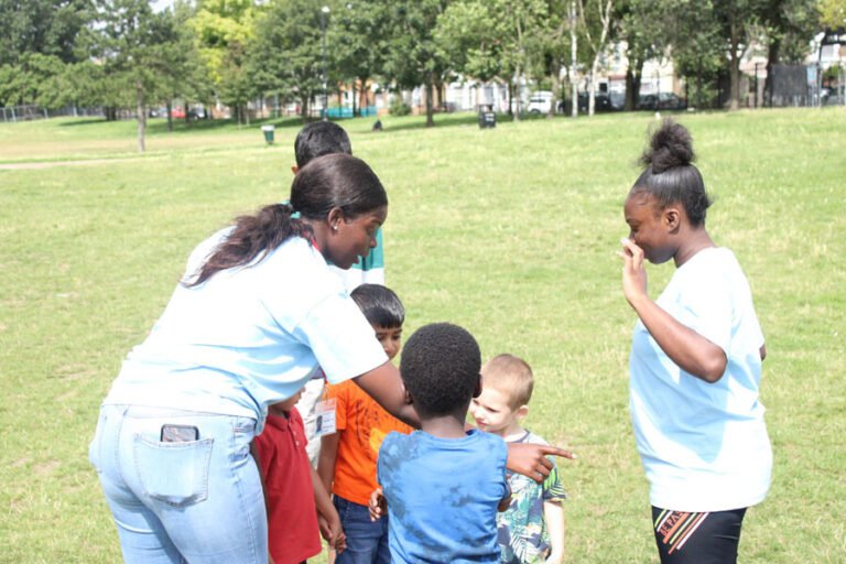Activity leaders supporting children during outdoor team play