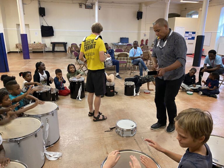 Children and activity leaders taking part in a drum workshop
