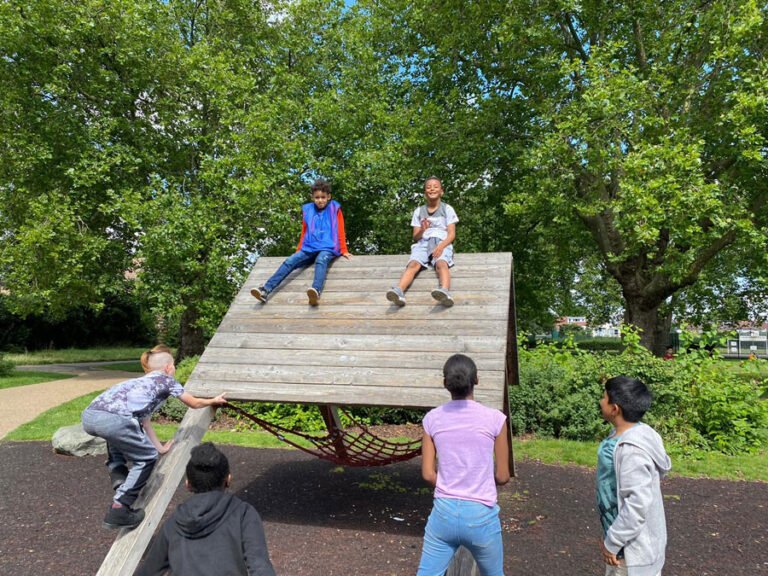 Children climbing and balancing on an outdoor play structure