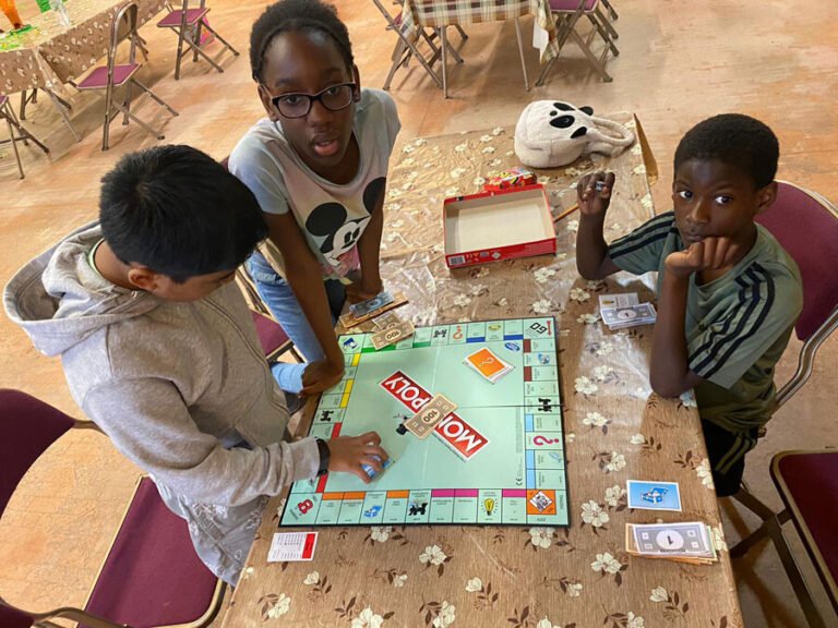 Children playing a board game together around a table